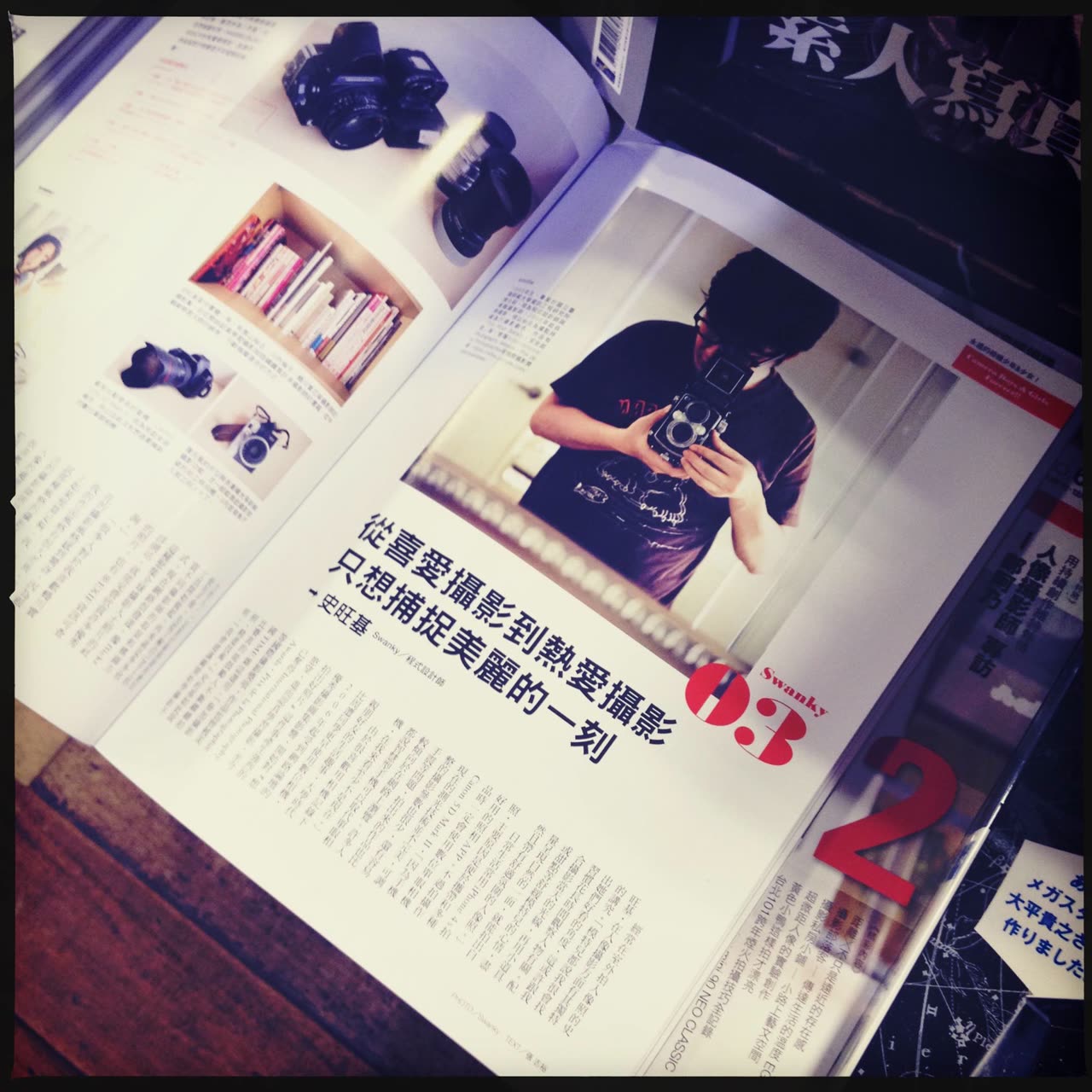 紙本攝影雜誌翻開的專訪版面，右頁為史旺基手持雙眼相機的人物照